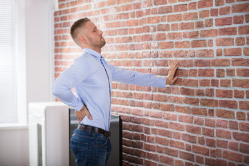 Man Touching His Back In Pain