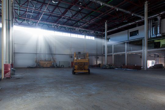 Scissor Lift In A Warehouse With Rays Of The Sun