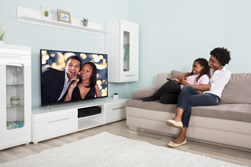 Happy Mother And Daughter Watching Television