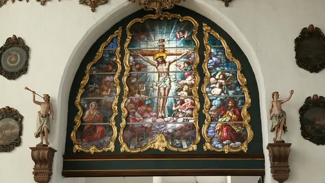 Stained-glass window with crucified Jesus and other saints, church interior