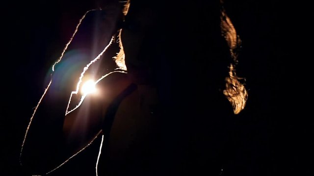 Silhouette of a strong woman boxing in the dark. Slow motion.
