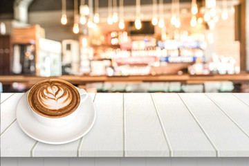 Coffee in a cup on white wooden table in cafe.