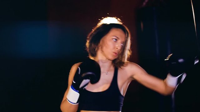 Woman boxing with a punching box.