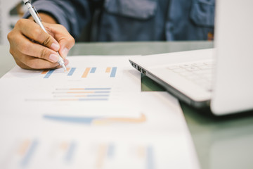 Silhouette Young businessmen analyze graphs and take notes to meet goals set over blurred office.Film Grain effect and select focus and Blurred Wide