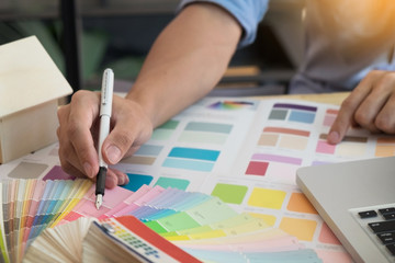 interior design and renovation and technology concept - graphic designer choosing proper color samples for selection on table.