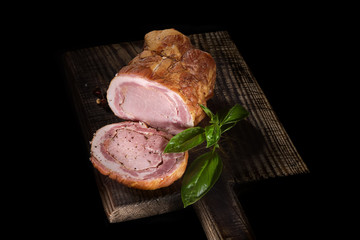 Rolled roasted pork meat on a cutting board