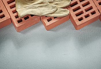 Red bricks leather protective gloves on concrete surface constru