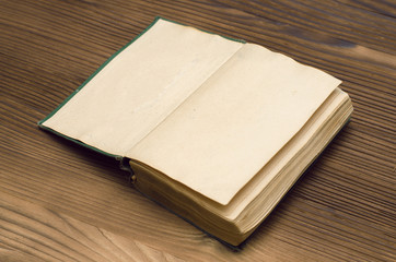 Open vintage book on the wooden table. Education or reading concept.