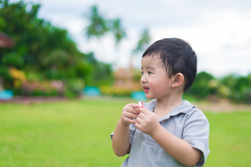 Little Asian kid at the playground under the sunlight, shallow DOF