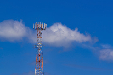 Mobile phone communication antenna tower with the blue sky and clouds