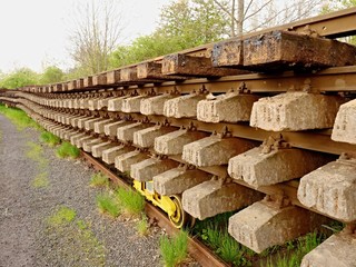 Wagon with extracted old railways. Concrete and wooden sleepers with rail rods