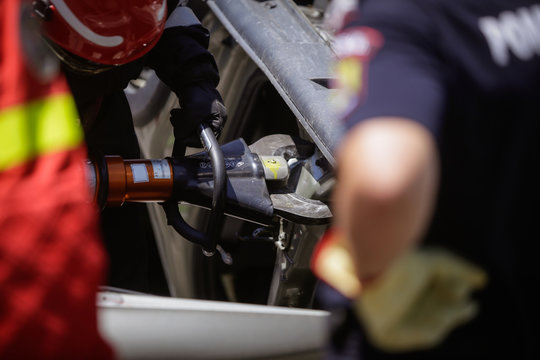 Rescue firefighters and paramedics take part in a vehicle extrication at a drill car crash site