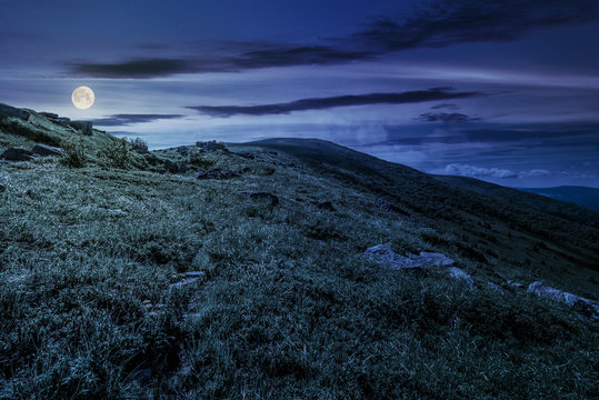 grassy hillside of mountain in summer at night