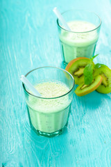 Kiwi smoothies in glass on wooden table