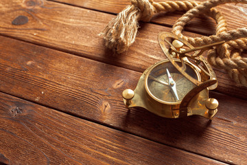 Compass and rope on wooden table. close up
