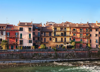 The picturesque views of the houses facades near the Adige river bank, Verona, Italy.
