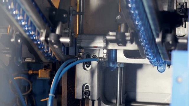 Two rows of bottle preforms transported for molding. 