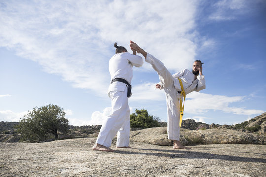 Man doing a high kick during a martial arts combat