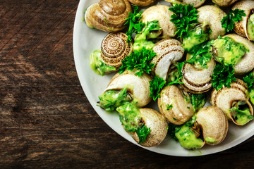 French snails in green butter and herbs sauce, overhead photo