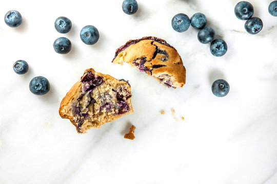 Two halves of blueberry muffin with fresh berries and copyspace