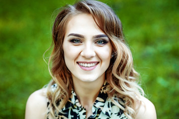 Naklejka premium Beautiful young girl smiling at the park. The concept of lifestyle and summer.