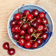 Fresh cherries berries in blue bowl, top view