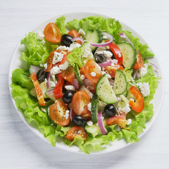 Fresh vegetable Greek salad on white background, top view