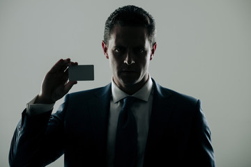 shadow business, businessman holding bank or business card