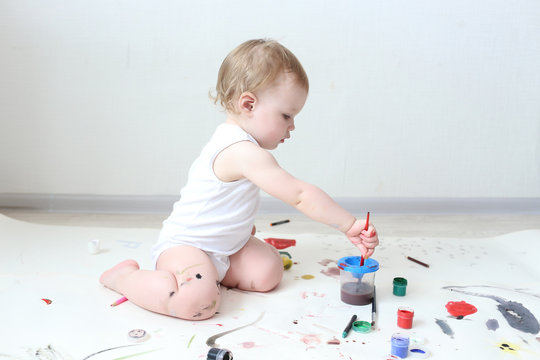 happy little 1 year baby girl painting at home