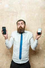 bearded man or hipster compare mobile phone and smartphone
