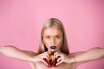 woman hold red paprika on the pink background, heart