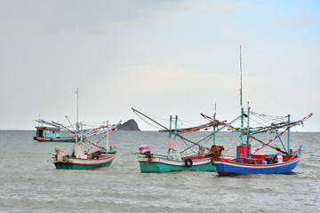 Many fishing boats float on the sea with blue sky background.