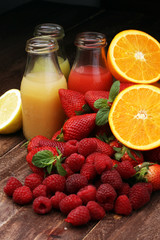 several bottles with fruit and berry juices smoothies and milksh