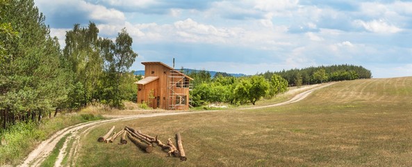 Panoramic view of building a green house near the forest. Construction of a family house. Timber...