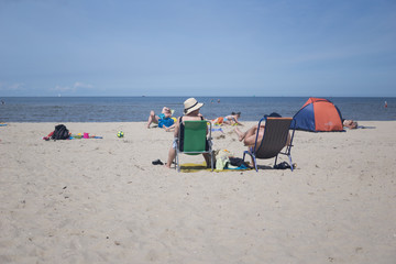 two elderly people relax on the beach