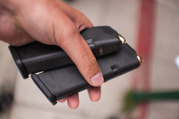 A man holds in his hand two magazines for a firearm