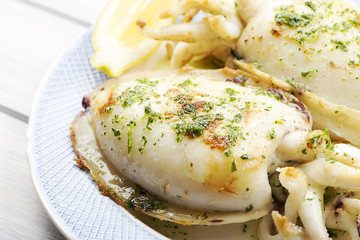 Close-up of cuttlefish with garlic and parsley next to lemon. Food.