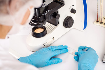 Professional scientist doing research with microscope in clinical laboratory. .