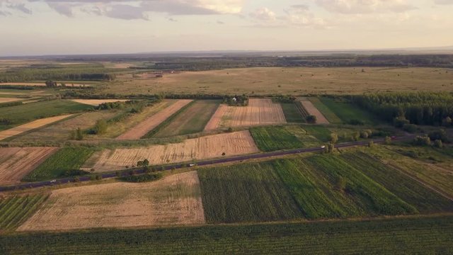 Beautiful aerial view of countryside and cultivated fields in sunset, drone point of view