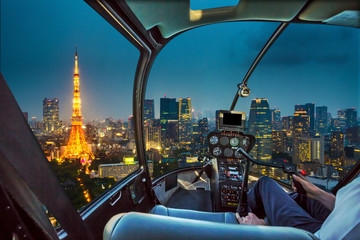 Helicopter flying on Tokyo Skyline at dusk with illuminated Tokyo Tower, icon and landmark of Minato Distric in Tokyo, Japan. - obrazy, fototapety, plakaty