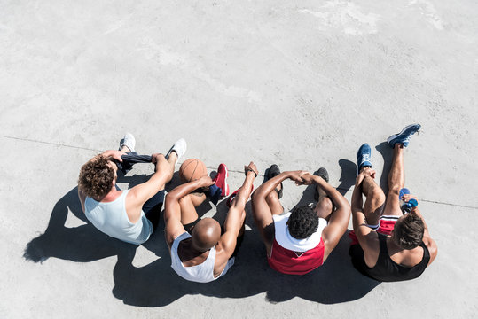 Overhead View Of Group Of Basketball Players Resting On Court After Game