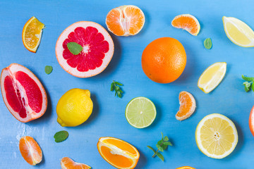 citrus slices food pattern on blue background - assorted sliced citrus fruits with mint leaves