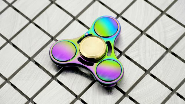 Toy fidget spiner on a  metal surface.
