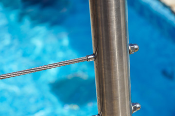 detail of thermal swimming pool tiled stairs down water and metal handle