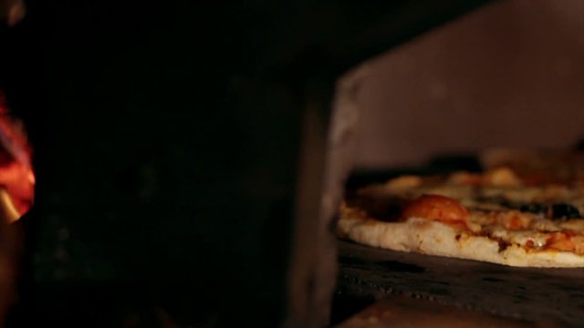 Italian restaurant kitchen cooking, Pizza baking in wood fired stove at pizzeria.