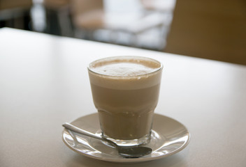 cup of coffee with milk over wooden table