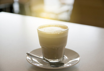 cup of coffee with milk over wooden table