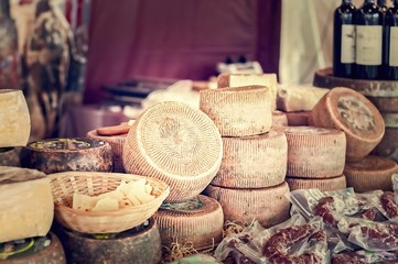 Cheeses and cut pieces on sale at market.