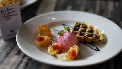 a sweet and tasty wafles with chocolate and strawberry ice cream.