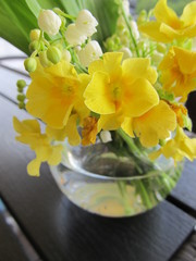 Decorative bouquet of yellow flowers in a small round vase on a table in a restaurant